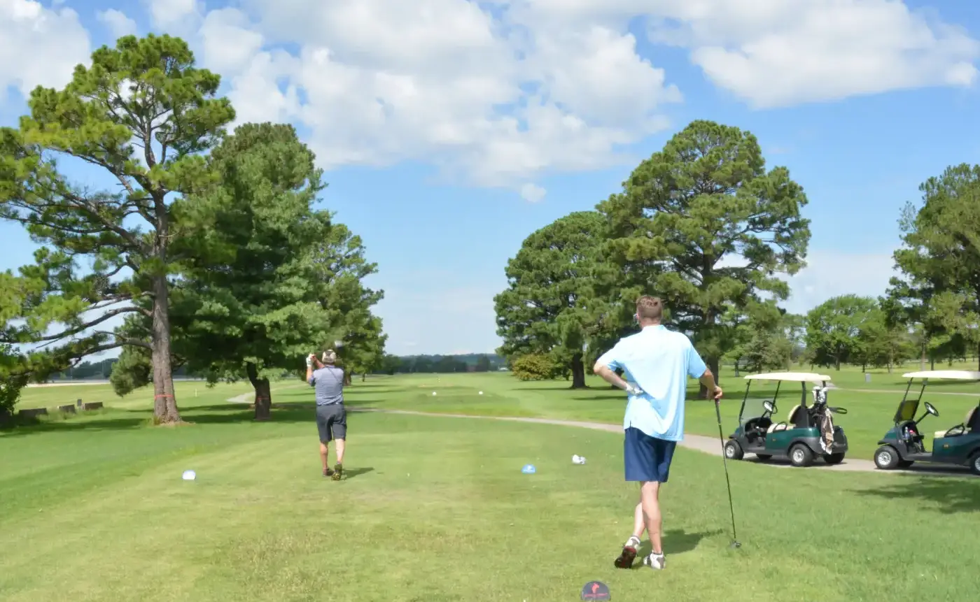 Scenic golf fairway lined with trees at sunrise